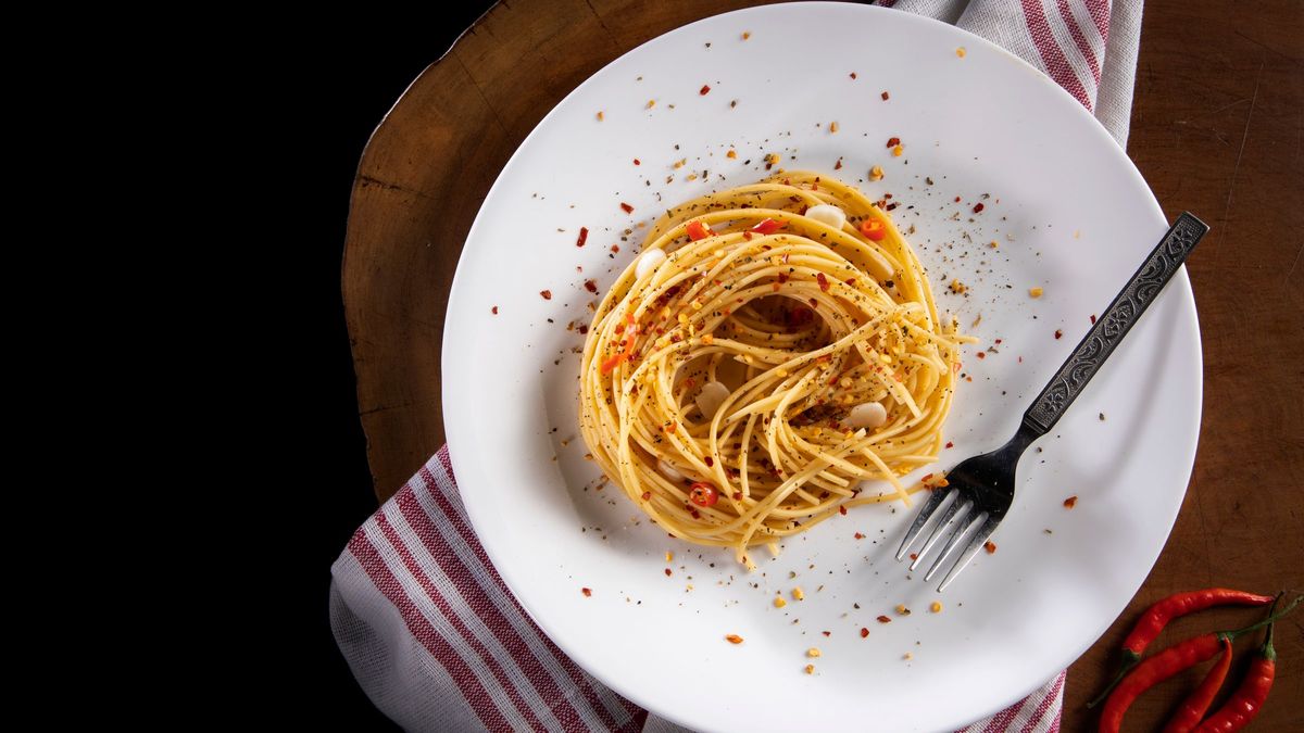 Spaghetti med hvidløg og chili på en hvid tallerken