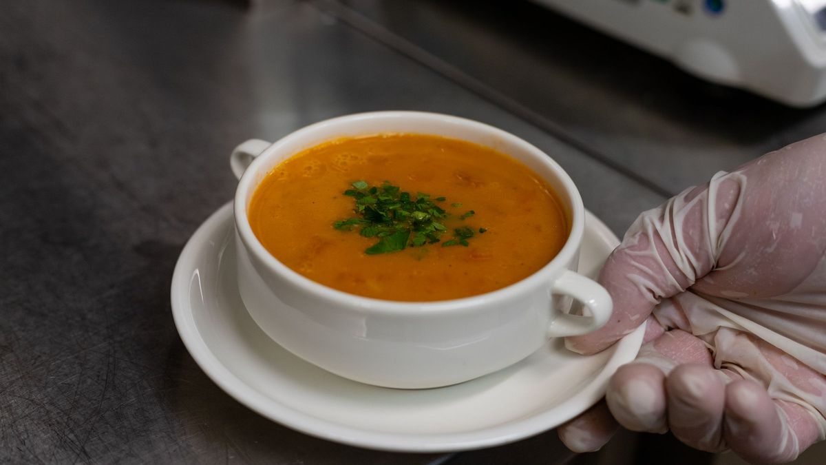 Skål med cremet orange suppe pyntet med persille